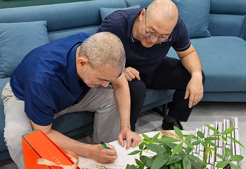 Ron facilitating a formal contract signing with a client in a modern corporate showroom.