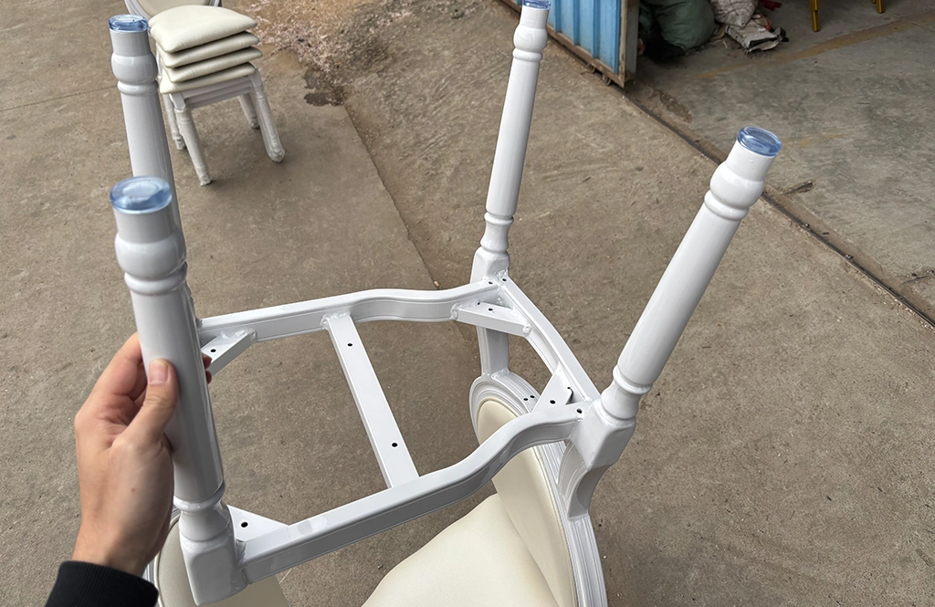 Underside of a white chair frame showing full welding points and structure.
