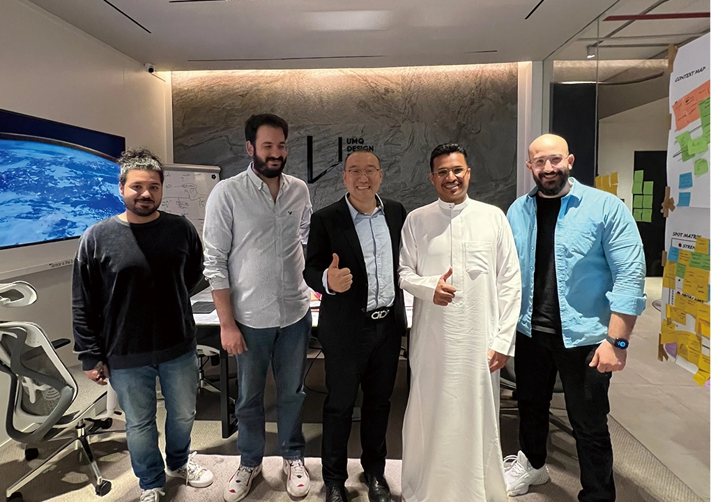 Ron Group team posing with Middle Eastern clients in a design studio