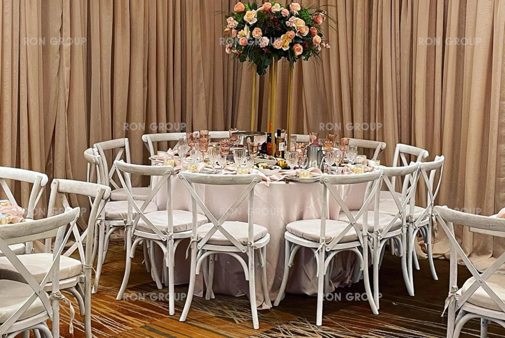 Rustic whitewashed cross back chairs at an indoor wedding reception