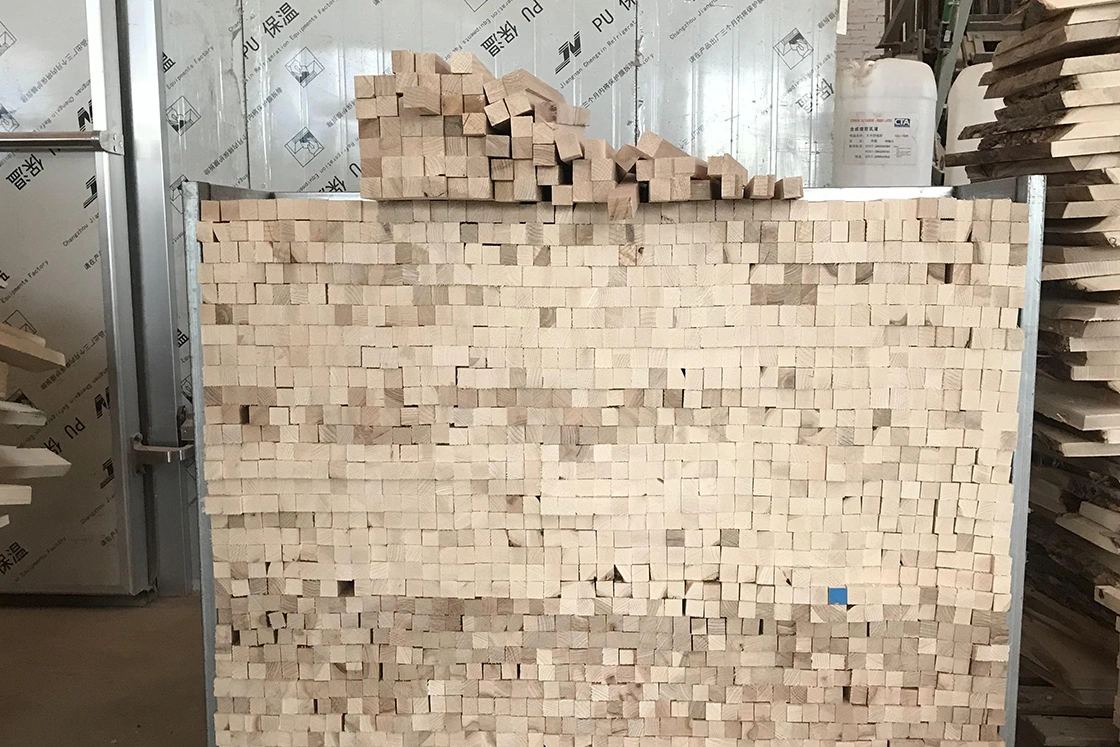 Stacked solid wood lumber undergoing drying and storage process.